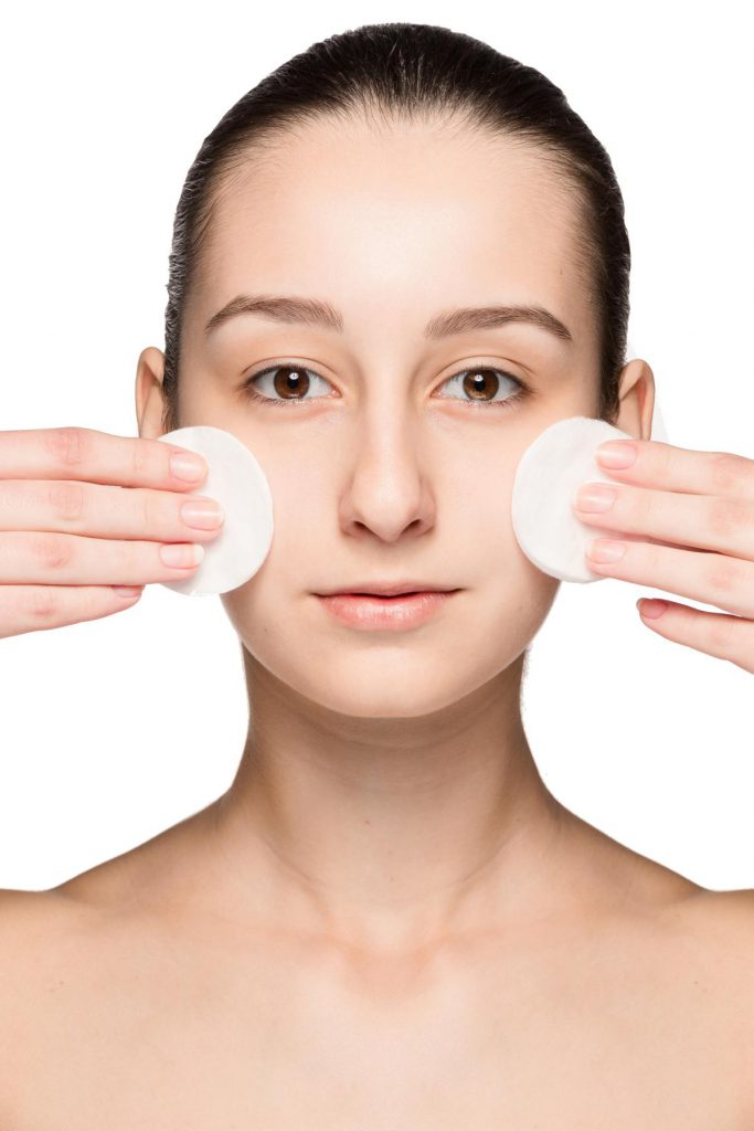 skin care woman removing face with cotton swabs